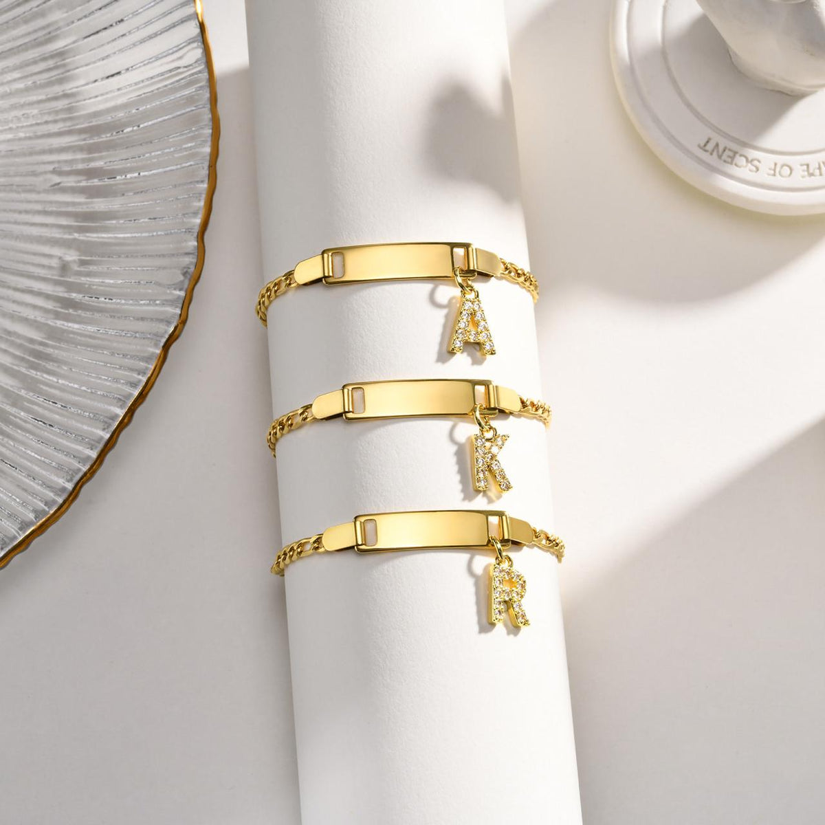 Gold letter charm bracelet displayed to highlight its delicate design and gold-plated finish.
