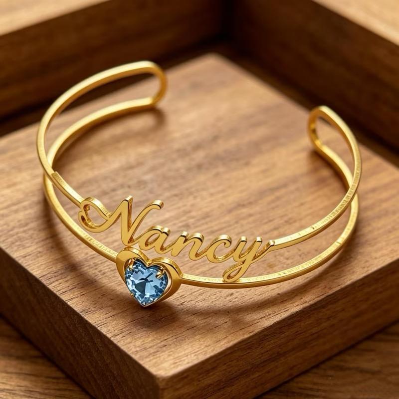 The Birthstone Charm Bangle displayed elegantly in a wooden jewellery box.
